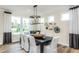 Elegant dining room with a modern chandelier, neutral decor, and large windows for natural light at 2404 Del Webb Gardens Dr, Fuquay Varina, NC 27526