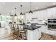 Modern kitchen featuring a large island with seating, stainless steel appliances, and stylish pendant lighting at 2404 Del Webb Gardens Dr, Fuquay Varina, NC 27526