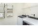 Bright laundry room with modern washer and dryer, storage shelves, and functional design at 2404 Del Webb Gardens Dr, Fuquay Varina, NC 27526