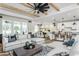 Spacious living room with a modern kitchen, a large sectional sofa, and stylish decor at 2404 Del Webb Gardens Dr, Fuquay Varina, NC 27526