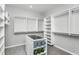 Spacious walk-in closet featuring custom shelving, an island with storage, and carpet flooring at 2404 Del Webb Gardens Dr, Fuquay Varina, NC 27526