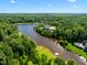 Wide summer aerial view of lakeside home and grounds surrounded by forest at 266 Perfect Moment Dr, Durham, NC 27713