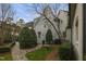 Beautiful backyard garden with brick path, mature trees, and white painted brick home at 266 Perfect Moment Dr, Durham, NC 27713