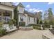 Beautiful landscaped backyard with a hot tub and a bench next to a luxury white brick house at 266 Perfect Moment Dr, Durham, NC 27713