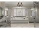 Luxurious bathroom showcasing a soaking tub, custom cabinetry, and decorative wallpaper at 266 Perfect Moment Dr, Durham, NC 27713