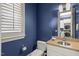 Half bath boasts blue walls, white cabinets and a window with views to the outside at 266 Perfect Moment Dr, Durham, NC 27713