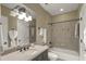 Well-lit bathroom featuring vanity, bath with shower, decorative wall tiles, and lots of storage at 266 Perfect Moment Dr, Durham, NC 27713