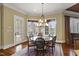 Dining room area with wood floors, rug, chandelier, and a view of the property's exterior at 266 Perfect Moment Dr, Durham, NC 27713