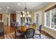 Formal dining room features a chandelier, access to the stairway, and light-filled views of the outdoors at 266 Perfect Moment Dr, Durham, NC 27713