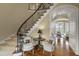 Grand foyer featuring a curved staircase with iron railing and elegant chandelier at 266 Perfect Moment Dr, Durham, NC 27713
