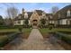 Elegant stone and white brick home featuring lush landscaping, walkway, and benches at 266 Perfect Moment Dr, Durham, NC 27713