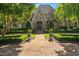 Beautiful stone-and-brick home with manicured landscaping, mature trees, and an inviting arched entryway at 266 Perfect Moment Dr, Durham, NC 27713