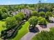 Elegant stone home with beautiful landscaping, mature trees, and a circular driveway create a luxurious curb appeal at 266 Perfect Moment Dr, Durham, NC 27713
