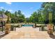 Beautiful in-ground swimming pool surrounded by lush greenery and a stone patio at 266 Perfect Moment Dr, Durham, NC 27713