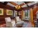 An elegant wood-paneled study with fireplace, coffered ceilings, and neutral armchairs at 266 Perfect Moment Dr, Durham, NC 27713