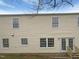 A two-story home's exterior with vinyl siding, several windows, and a back door with stairs at 4 Birkdale Ct, Durham, NC 27713