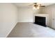 An empty living room with a fireplace, ceiling fan, neutral carpet and access to the backyard at 4 Birkdale Ct, Durham, NC 27713