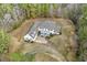 Aerial view of a two-story house with a large yard and driveway surrounded by trees at 419 Eagle Point Rd, Pittsboro, NC 27312