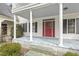 Inviting front porch with blue painted floors, white columns, and a vibrant red front door at 419 Eagle Point Rd, Pittsboro, NC 27312