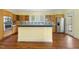 Traditional eat-in kitchen features wood cabinets, tile backsplash, stainless steel appliances, and beautiful hardwood floors at 419 Eagle Point Rd, Pittsboro, NC 27312