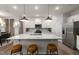 Bright kitchen features an island with granite countertops, pendant lighting, and stainless steel appliances at 424 Providence Springs Ln, Fuquay Varina, NC 27526