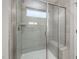 Contemporary walk-in shower featuring gray tile, glass door, shower bench, and a window at 424 Providence Springs Ln, Fuquay Varina, NC 27526