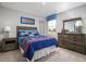 Themed bedroom with a queen-sized bed, fun bedding, and wooden furniture at 428 Autumn Moon Dr, Zebulon, NC 27597
