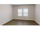 Comfortable bedroom boasts wood floors, two large windows with blinds, and neutral paint, creating a relaxing ambiance at 46 Coffee Tree Cir, Clayton, NC 27527