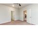Neutral bedroom with carpet, ceiling fan, and an open door leading to the kitchen at 504 Rhino Bnd, Oxford, NC 27565