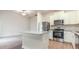 Modern kitchen with white cabinets, granite island, and stainless steel appliances blending with the living area at 504 Rhino Bnd, Oxford, NC 27565