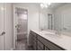 Bright bathroom featuring a double vanity with a large mirror and an open doorway to a separate shower/tub area at 505 Providence Springs Ln, Fuquay Varina, NC 27526