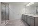 Spacious bathroom with a walk-in shower with glass door and double vanity with gray cabinets at 505 Providence Springs Ln, Fuquay Varina, NC 27526