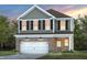 Charming two-story home featuring a brick-accented facade, attached garage and manicured lawn at 505 Providence Springs Ln, Fuquay Varina, NC 27526