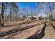 Scenic backyard with mature trees and gentle slopes leading to the residence at 513 W Glendale St, Siler City, NC 27344