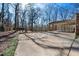 Large driveway with a covered parking area surrounded by mature trees at 513 W Glendale St, Siler City, NC 27344