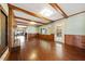 Spacious living room featuring hardwood floors, a brick fireplace, exposed wood beams, and wainscoting detail at 513 W Glendale St, Siler City, NC 27344