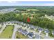 Aerial shot of a neighborhood with tree-lined streets and sidewalks surrounded by green fields at 622 Lone Pine Loop, Fuquay Varina, NC 27526