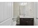 Well-lit bathroom features a dark vanity with a sink, mirror, and white door at 622 Lone Pine Loop, Fuquay Varina, NC 27526