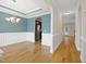 Inviting dining room with elegant chandelier, wainscoting, and hardwood floors with arched passageway to kitchen at 622 Lone Pine Loop, Fuquay Varina, NC 27526