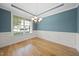 Well-lit dining area with hardwood floors, a modern chandelier, and detailed wainscoting at 622 Lone Pine Loop, Fuquay Varina, NC 27526