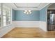 Bright dining room featuring hardwood floors, large window, and stylish chandelier for elegant dining at 622 Lone Pine Loop, Fuquay Varina, NC 27526