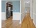 Hallway with beautiful hardwood flooring leading to the kitchen with stainless steel appliances at 622 Lone Pine Loop, Fuquay Varina, NC 27526