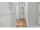 Hallway with hardwood floors, built-in shelving, and neutral paint offers functionality and style at 622 Lone Pine Loop, Fuquay Varina, NC 27526