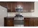Modern kitchen with dark wood cabinets, granite countertops, and stainless steel appliances, including gas range at 622 Lone Pine Loop, Fuquay Varina, NC 27526