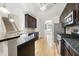 Modern kitchen with granite countertops, dark cabinets, and stainless steel appliances, and open to dining area at 622 Lone Pine Loop, Fuquay Varina, NC 27526