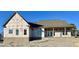 New home construction with brick base, covered porch, large windows, and architectural roof on a sunny day at 6312 River Rd, Fuquay Varina, NC 27526