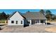 New construction home with brick base, covered porch, large windows, and stylish architectural details at 6312 River Rd, Fuquay Varina, NC 27526