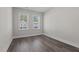 Well lit bedroom featuring wood-look flooring, neutral walls and two windows with privacy blinds at 716 Jamescroft Way # 28, Rolesville, NC 27571