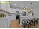 Stylish kitchen features white cabinetry, stainless steel appliances, island with seating, pendant lighting, and sleek countertops at 716 Jamescroft Way # 28, Rolesville, NC 27571
