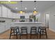 Bright kitchen boasts white cabinets, stainless steel appliances, an island with bar seating, and modern pendant lighting at 716 Jamescroft Way # 28, Rolesville, NC 27571